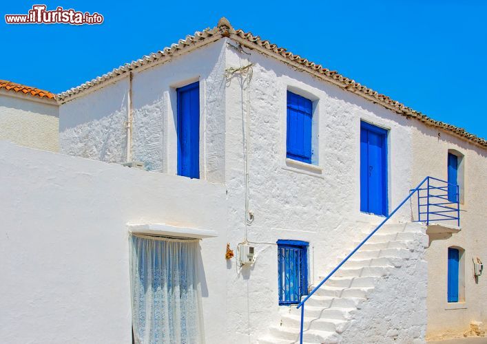 Immagine Una tradizionale casa bianca con porte e finestre blu sull'isola di Angistri, Grecia - © imagIN.gr photography / Shutterstock.com