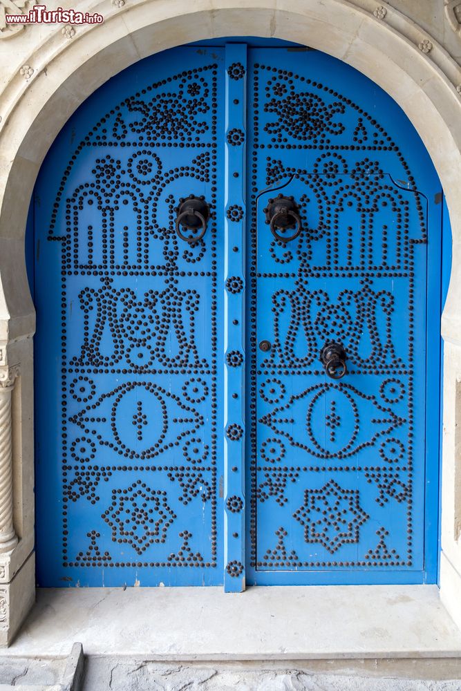 Immagine Una tradizionale porta tunisina nel centro di Sfax. L'architettura araba mediterranea prevede porte in legno finemente decorate e dipinte nelle tonalità dell'azzurro e del blu. 