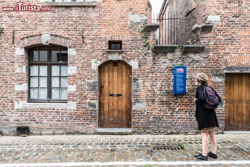 Immagine Una turista in attesa dell'apertura del Museo del Folklore a Tournai, Belgio. Ospitato in un edificio del XVII° secolo, questo percorso museale si apre su 23 sale con una superficie totale di 1100 metri quadrati - © Werner Lerooy / Shutterstock.com