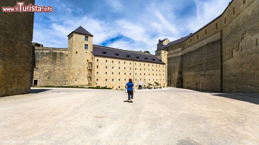 Immagine Una turista nel cortile del castello di Sedan, Ardenne, in una giornata estiva (Francia) - © vvoe / Shutterstock.com