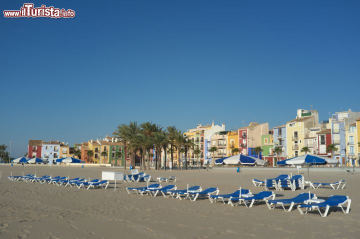 Immagine Una vasta spiaggia attrezzata a La Vila Joiosa, Spagna. Si tratta di uno dei tratti costieri più frequentati dai turisti durante buona parte dell'anno: le cime delle catene montuose Puig Campana e Aitana formano una barriera contro i venti del nord mantenendo così temperature sempre piacevoli.