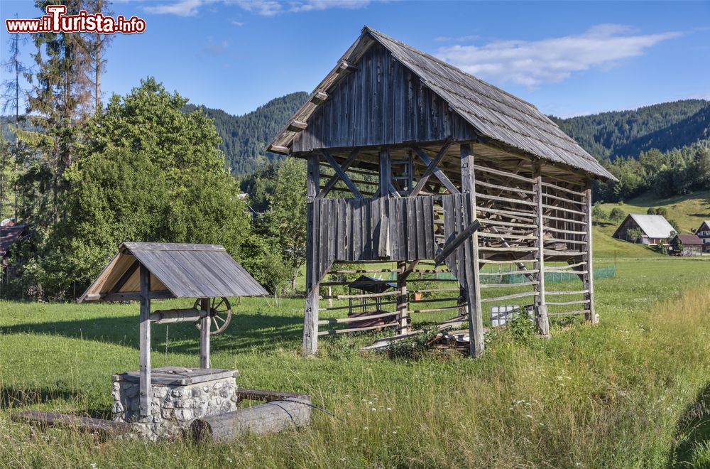 Immagine Una vecchia fontana e una rastrelliera per il fieno in un villaggio di montagna a Bohinj, Slovenia.