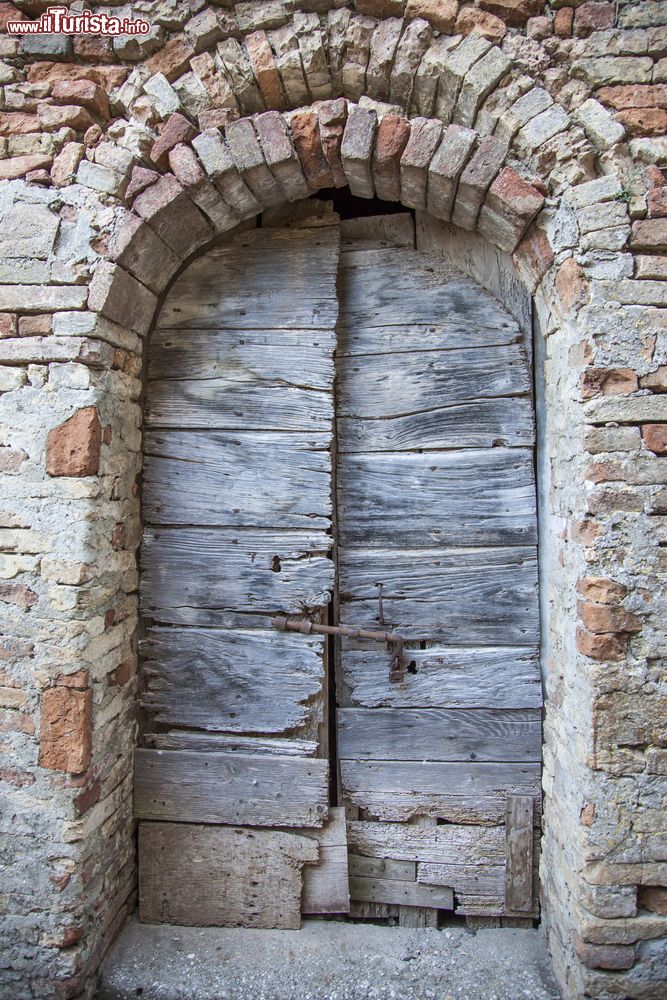 Immagine Una vecchia porta in legno con chiavistello nella città di Ripatransone, Marche, Italia. Passeggiando per il centro storico del borgo medievale se ne possono scorgere angoli pittoreschi.