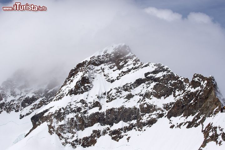 Immagine Una vetta innevata dello Jungfrau, Grindelwald, Svizzera, fotografata in una giornata nuvolosa.