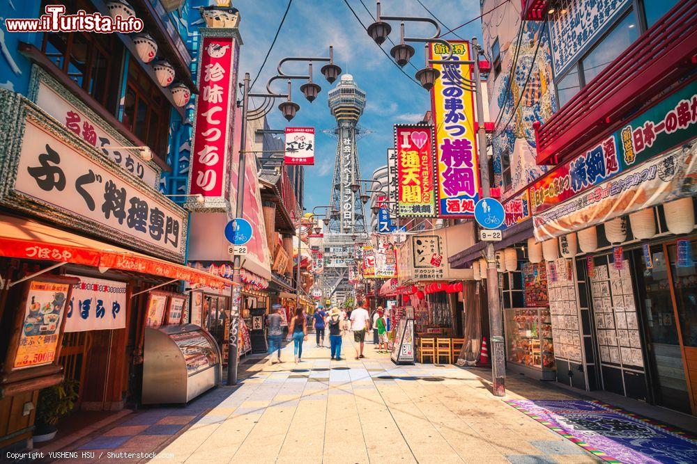 Immagine Una via pedonale di Osaka, Giappone, con negozi e attività commerciali. Sullo sfondo, la Tsutenkaku Tower - © YUSHENG HSU / Shutterstock.com