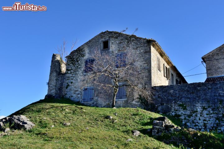 Immagine Un'antica casa in pietra nel borgo di Hum, Croazia, immersa nel verde - © Natalija Sahraj / Shutterstock.com