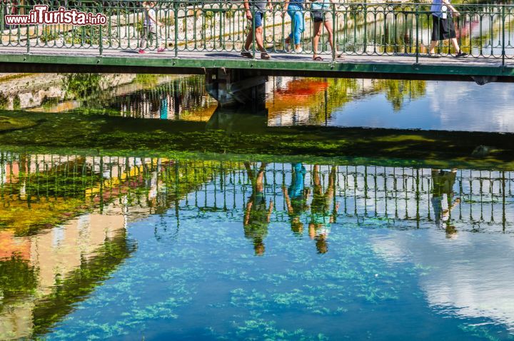 Immagine Il riflesso dei passanti sulle acque di un canale di L'Isle-sur-la-Sorgue. La città è attraversata da una miriade di canali e ponticelli - © Emanuele Mazzoni Photo / Shutterstock.com