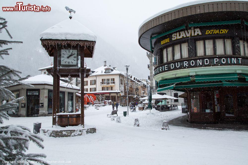 Immagine Uno scorcio del centro storico di Chamonix in inverno con la neve (Francia): la piazza centrale, l'orologio e i caffé di uno dei resort sciistici più antichi delle Alpi francesi - © Nataliya Nazarova / Shutterstock.com