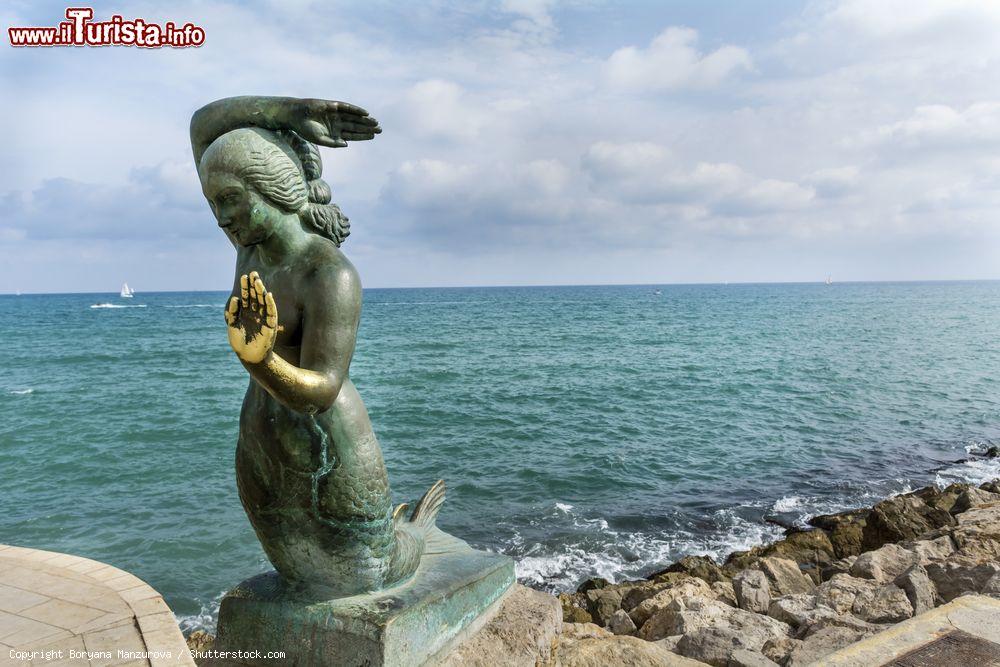 Immagine Uno scorcio del litorale roccioso di Sitges con la statua di una sirena, Catalogna, Spagna - © Boryana Manzurova / Shutterstock.com