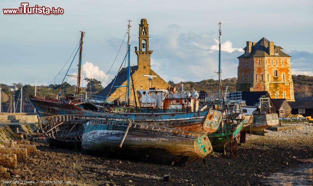 Immagine Uno scorcio del porto di Camaret-sur-Mer in Bretagna, Francia. Nella foto, relitti di barche per la pesca delle aragoste con sullo sfondo due monumenti storici della città, la Torre Vauban e la chiesa di Nostra Signora di Rocamadour - © zjtmath / Shutterstock.com