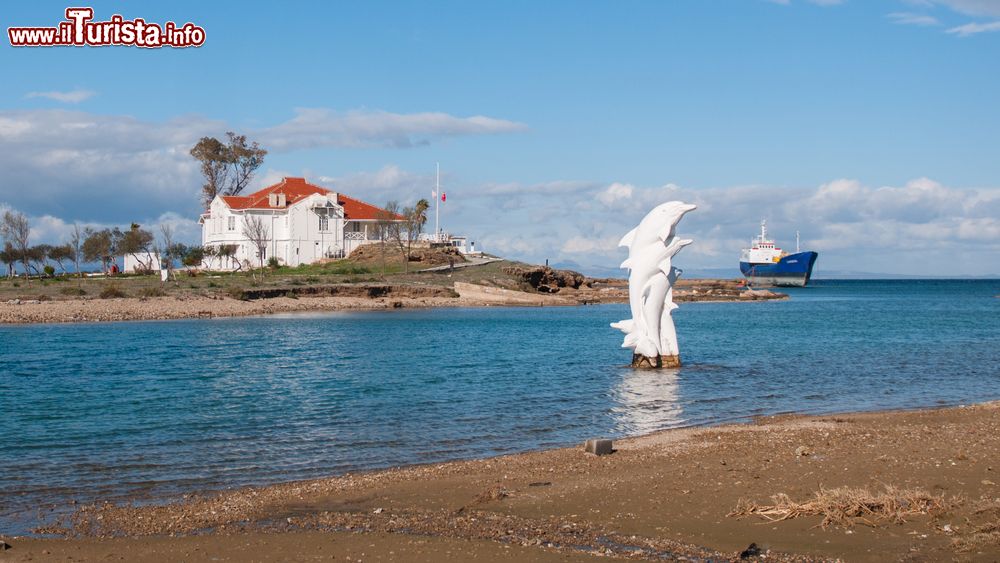 Immagine Uno scorcio di Famagosta, Cipro Nord: una bella casa, una nave abbandonata e un monumento ai delfini.