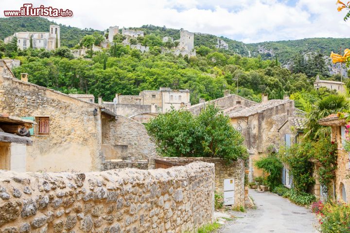 Immagine Uno scorcio panoramico di Gordes, Francia - Circondato da campi, boschi e da altri piccoli villaggi arroccati sulle montagne, questo splendido borgo fortificato attira turisti provenienti da tutto il mondo grazie anche al suo castello del dodicesimo secolo che svetta imponente su tutta la città e la vallata © ISchmidt / Shutterstock.com