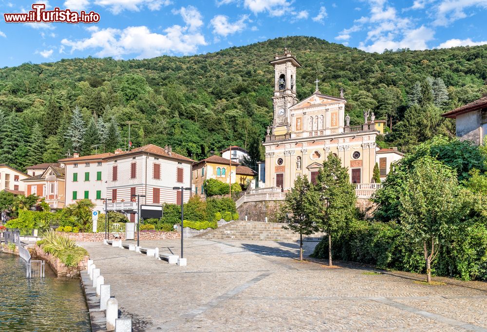 Immagine Uno scorcio di Porto Ceresio con la chiesa, Varese, Lombardia. Questa rilassante cittadina affacciata sul lago ospita monumenti storici e edifici religiosi di grande pregio fra cui la chiesa di Sant'Ambrogio di fine XVI° secolo con decorazioni barocche-lombarde.