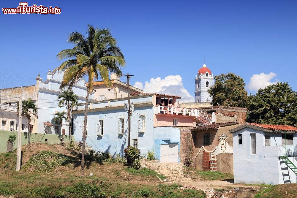 Immagine Uno scorcio panoramico di Sancti Spiritus, Cuba, con palme e edifici. Immersa nella natura, le sue principali attività sono l'agricoltura della canna da zucchero, l'allevamento bovino, la coltivazione di tuberi e verdure.