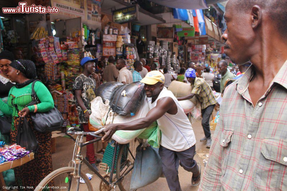 Immagine Uomini spingono bici cariche di merci al mercato Kikuubo di Kampala, Uganda. Siamo in uno dei principali mercati cittadini - © Tim Hook / Shutterstock.com