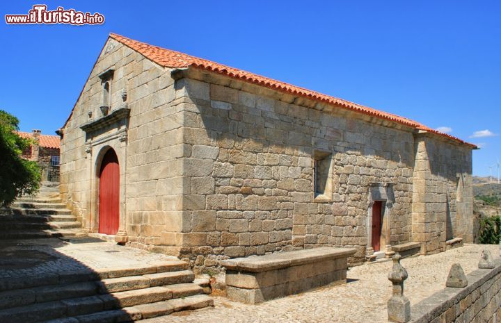 Immagine Vecchia chiesa a Sortelha, Portogallo - La graziosa chiesa parrocchiale di Sortelha si trova nel cuore del borgo vecchio vicino alle rovine di un piccolo castello. Più in alto domina la torre campanaria dalla cui sommità si può ammirare un'ampia vista sull'intero villaggio © Vector99 / Shutterstock.com