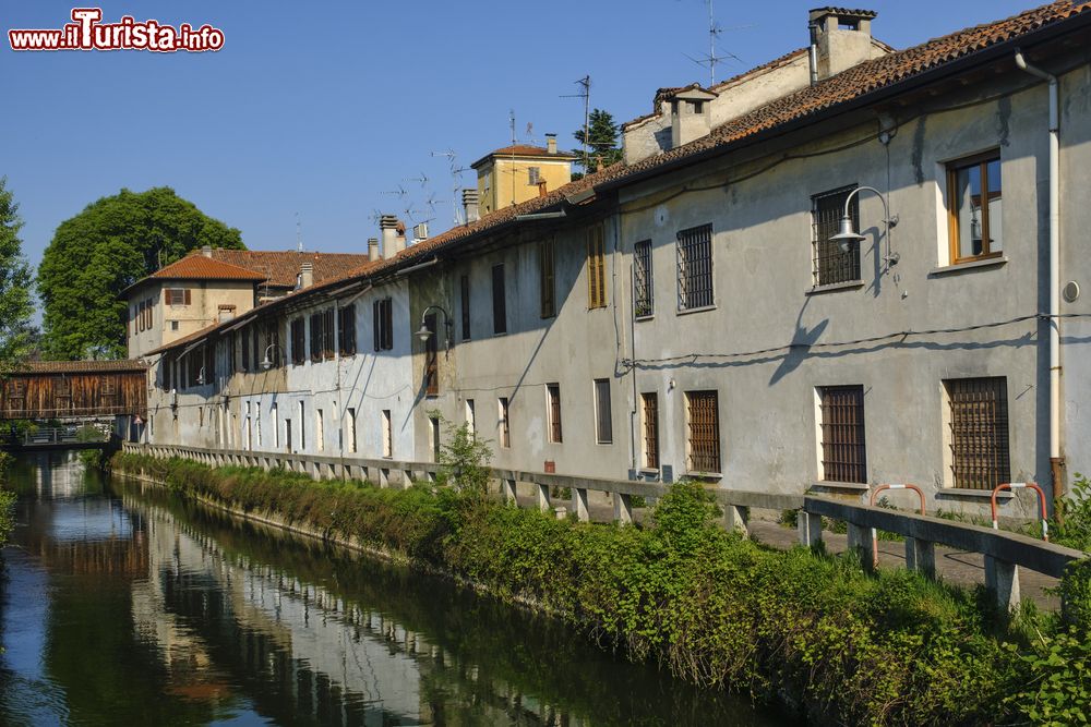 Immagine Vecchie case affacciate sul canale della Martesana a Gorgonzola, provincia di Milano, Lombardia. Sullo sfondo un ponte in legno e lungo il canale la pista ciclabile.