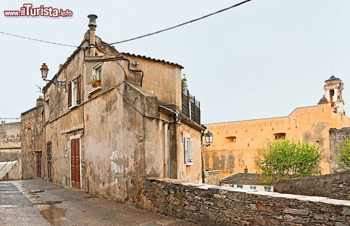 Immagine Vecchio edificio con la Cittadella Genovese sullo sfondo, Bastia. Palazzo dei Governatori, in origine una semplice torre, fu presto trasformato in un castello per la difesa della città. Oggi ospita il museo etnografico di Bastia - © eFesenko / Shutterstock.com