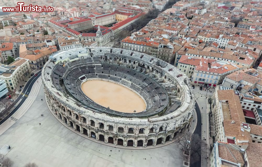 Immagine Veduta aerea dell'anfiteatro romano di Nimes, Occitania, Francia: costruito per ospitare spettacoli per il divertimento della popolazione, ai tempi delle invasioni barbariche fu riconvertito in fortezza e nel 1863 in teatro. Da allora accoglie eventi di ogni genere fra cui le corride dei tori.