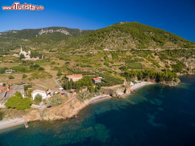 Immagine Veduta aerea dell'isola di Vis con la spiaggia e la chiesa di San Nicola, Croazia. Distante circa 60 miglia dalla costa italiana, quest'isola croata si estende per circa 90 km quadrati. Dedita alla pesca e all'agricoltura, questo territorio vanta baie incantevoli e lagune nascoste circondate da un mare limpido e cristallino - © paul prescott / Shutterstock.com