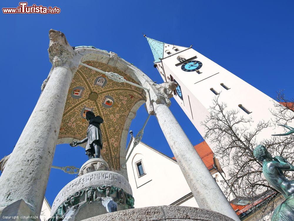 Immagine Veduta dal basso di una statua e della torre dell'orologio a Kempten, Germania - © cityfoto24 / Shutterstock.com