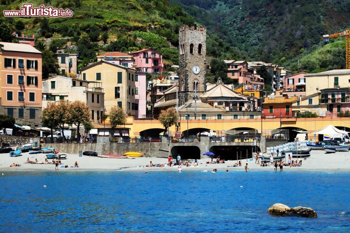 Immagine Veduta di Monterosso al Mare, Liguria - La spiaggia del borgo con alle spalle l'antico villaggio di Monterosso. Nel centro storico si distingue bene il campanile della chiesa di San Giovanni Battista, basilica a tre navate che si allargano verso l'altare. La torre merlata, a base quadrangolare, risale al periodo medievale © Mikadun / Shutterstock.com