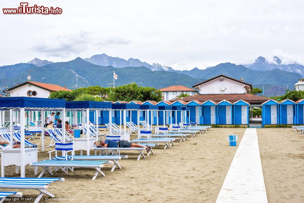 Immagine Veduta di una spiaggia di Forte dei Marmi, Toscana, in una giornata nuvolosa. Sullo sfondo le montagne e il cielo grigio - © FrimuFilms / Shutterstock.com
