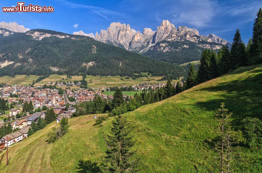 Immagine Veduta estiva della Val di Fassa con il villaggio di Pozza sullo sfondo, Trentino Alto Adige. In estate si possono effettuare passeggiate nei boschi per raccogliere bacche e funghi ma anche arrampicate sportive e escursioni sino ai rifugi.