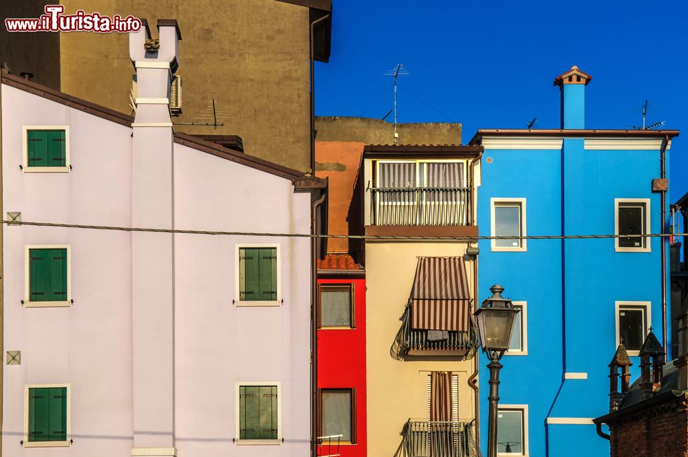 Immagine Veduta fotografica di una strada con le sue case dalle facciate variopinte a Chioggia, Veneto, Italia.