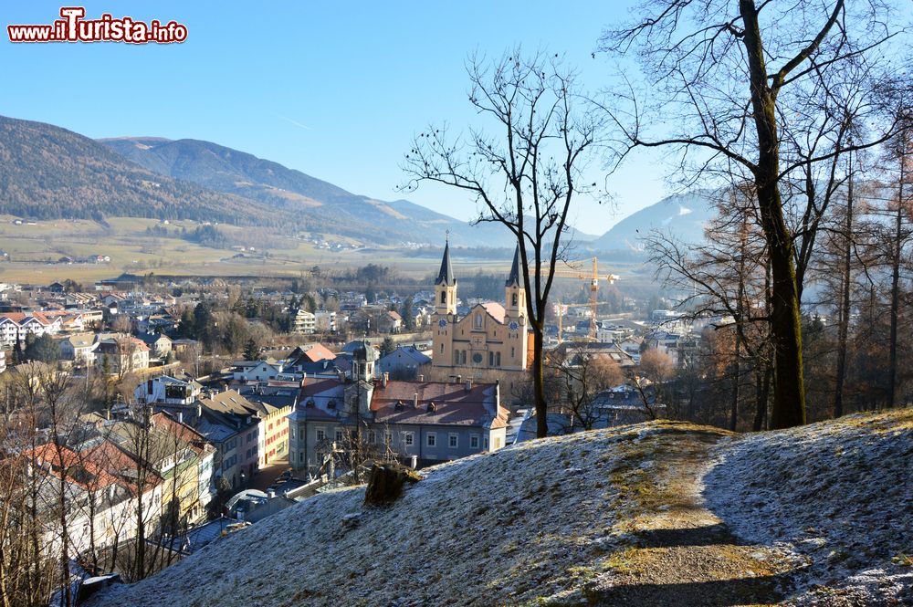 Immagine Veduta invernale di Brunico con la chiesa di Santa Maria Assunta, provincia di Bolzano, Trentino Alto Adige. Siamo nel capoluogo storico, culturale, economico e amministrativo della Val Pusteria.