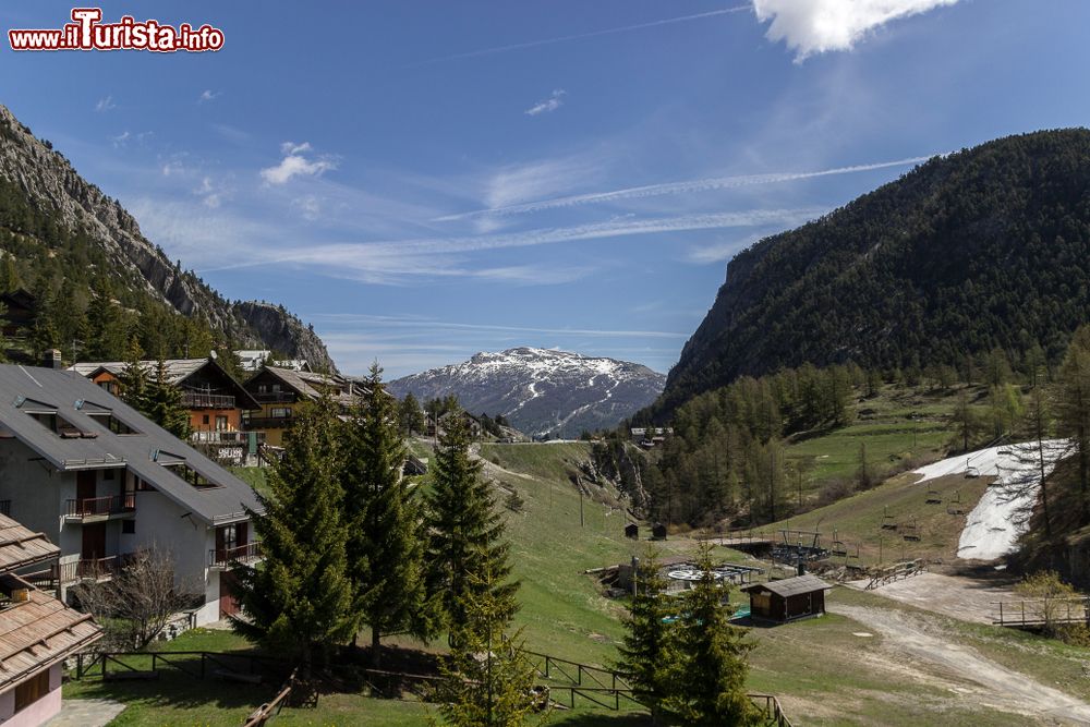 Immagine Veduta panoramica di Claviere in primavera con la neve sulle cime più alte, Piemonte. Sulla destra, uno scorcio della seggiovia.