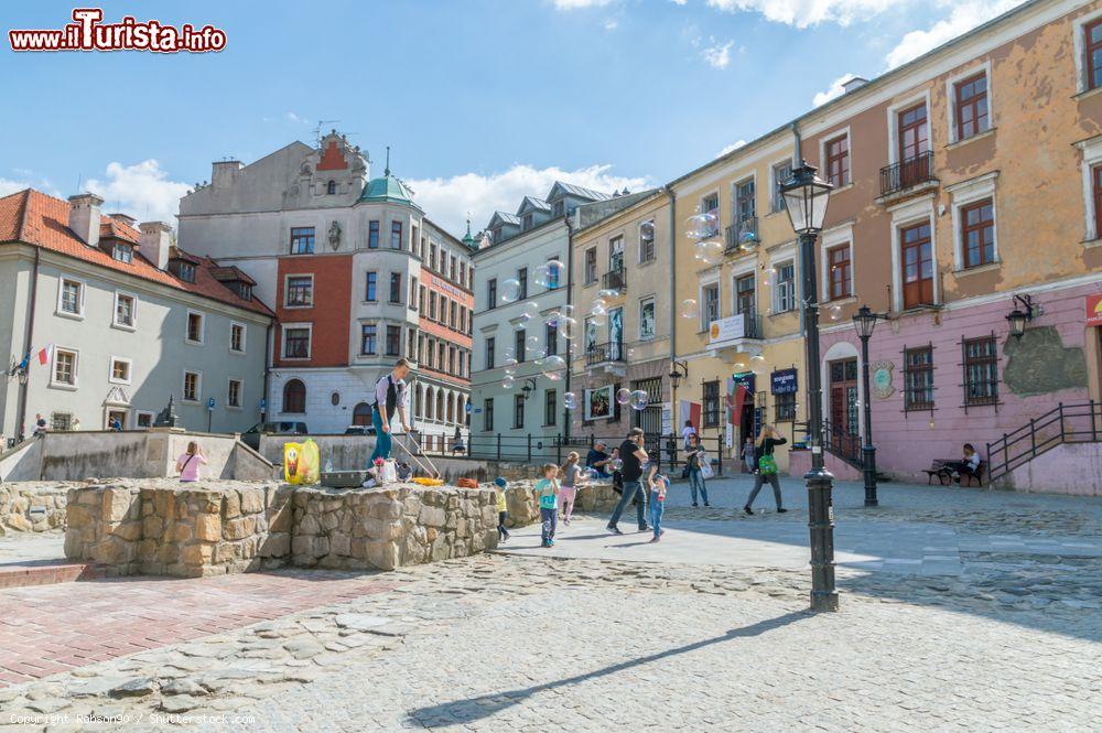 Immagine Veduta panoramica di Po Farze Square a Lublino, Polonia: sulle fondamenta della chiesa parrocchiale un artista di strada fa bolle con il sapone  - © Robson90 / Shutterstock.com