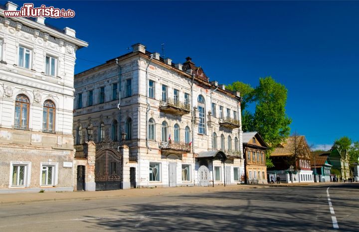 Immagine Tutte le vie di Kostroma dipartono a raggiera, come i rami di un ventaglio, dalla principale piazza della città dedicata all'eroe nazionale Ivan Susanin e conosciuta anche come "piazza della padella". Secondo la tradizione, questo nome deriverebbe dal fatto che nei secoli scorsi le carrozze trainate dai cavalli circolavano così tante volte attorno agli edifici che disegnarono sul selciato una forma piana e liscia come quella di una pentola. In questa immagine, una delle vie del centro cittadino su cui si affacciano ancora oggi bei palazzi d'epoca - © krechet / Shutterstock.com