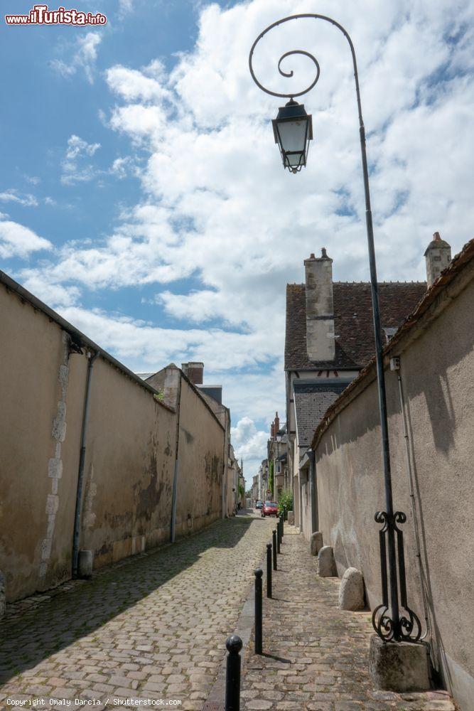 Immagine Un vicoletto acciottolato nel centro di Bourges, Francia, con un lampione in ferro battuto in primo piano - © Omaly Darcia / Shutterstock.com