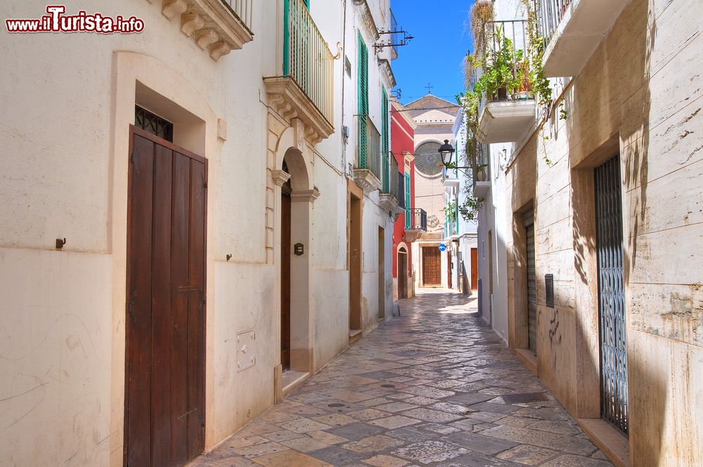 Immagine Un vicolo nel centro storico di Fasano, Puglia, Italia. Sullo sfondo una delle tante chiese che impreziosiscono questa cittadina in provincia di Brindisi.