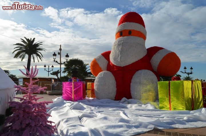 Immagine La grande statua di Babbo Natale all'interno del villaggio natalizio di Place De Gaulle. Alle spalle il lungomare di Ajaccio