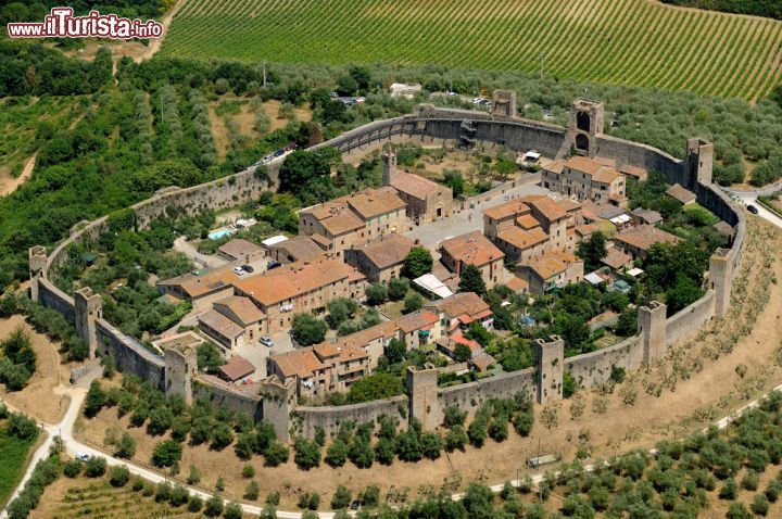 Immagine Veduta aerea del Borgo di Monteriggioni (Toscana) - In questa immagine che fortunatamente abbraccia tutto il perimetro delle fortificazioni, si riesce a vedere in modo chiaro la bellezza di questo borgo toscano. Si tratta di un'estensione di circa 570 metri, spiccano poi le 15 torri (14 esterne e 1 interna). Un grandissimo spettacolo medievale ammirabile oggi, un reperto storico e architettonico importantissimo e dalla bellezza visiva straordinaria - © stefano marinari / Shutterstock.com