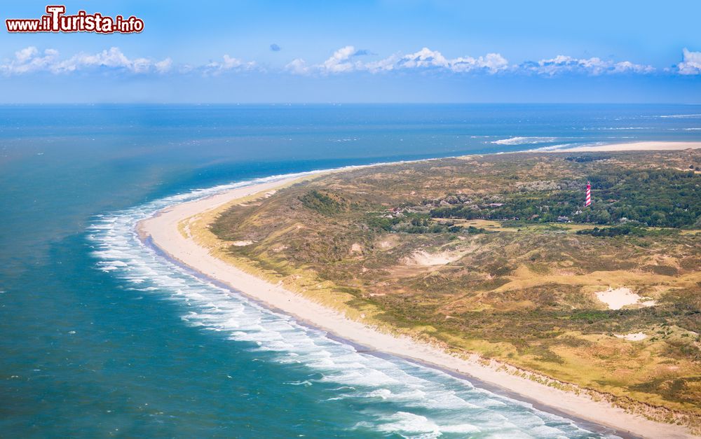 Immagine Vista aerea delle dune di sabbia e di una spiaggia con faro rosso nella provincia di Zeeland, Paesi Bassi.