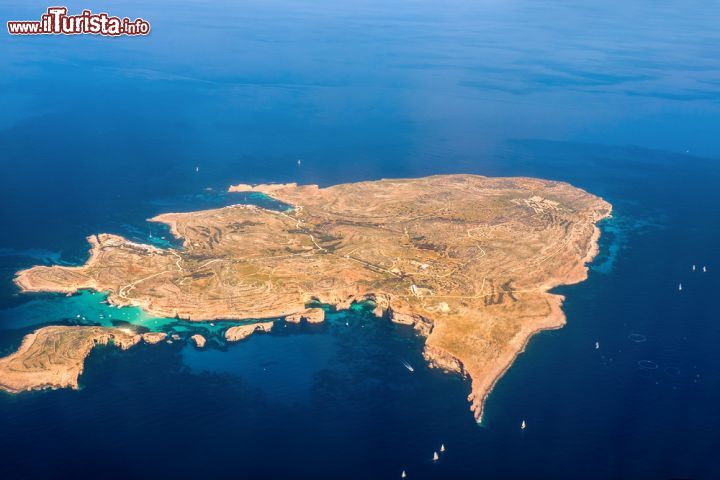 Immagine Fotografia aerea di Comino, Malta - Kemmuna, nome in maltese di questa terra dell'arcipelago delle Calipsee, si trova nel canale di Gozo fra le isole di Malta e Gozo nelle acque del Mare Mediterraneo. Ha un'estensione di circa 3,5 km quadrati e deve il suo nome proprio al cumino, una delle rare piante che in epoche passate cresceva sul suo arido suolo. In questa immagine, una suggestiva vista aerea di Comino, in antichità conosciuta anche con il nome di Ephestia  - © Lukas Jonaitis / Shutterstock.com