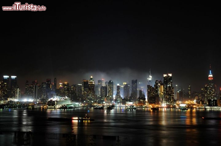 Immagine Panorama notturno dell'East river con skyline di New York City visto da Brooklyn, Stati Uniti. Una suggestiva immagine by night dei grattacieli della "grande mela" che si rispecchiano nell'East river: lo scorcio panoramico che si ha da Brooklyn è davvero mozzafiato - © Lauren Orr  / Shutterstock.com