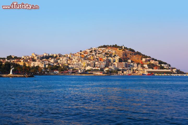 Immagine Vista su Kusadasi, Turchia - La città turca illuminata dai raggi del sole mattutini. Sul lungomare di Kusadasi, a sinistra dell'immagine fotografica, si intravede un interessante monumento alla pace simboleggiato da una grande mano aperta che accoglie colombe nere e bianche © Tatiana Popova / Shutterstock.com