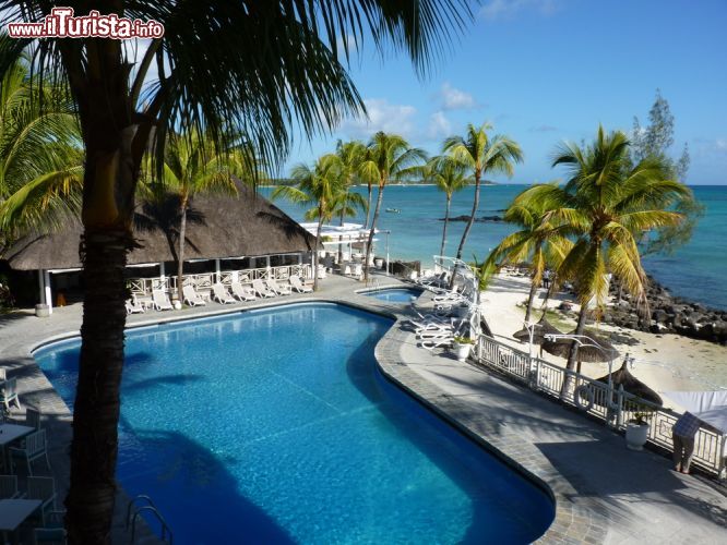 Immagine Vista sulla piscina di un hotel di lusso a Belle Mare, Mauritius - Uno spettacolare scorcio panoramico sulla piscina di uno dei resort lussuosi ospitati a Belle Mare, sulla costa orientale dell'isola di Mauritius. All'ombra delle palme ci si può rilassare immersi nelle acque della piscina ammirando la vastità dell'Oceano Indiano © boivin nicolas / Shutterstock.com