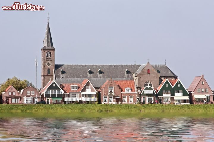 Immagine Panorama di Volendam, Olanda - Il suo aspetto è particolarmente incantevole arrivando in battello. Il villaggio è costruito lungo la diga intorno a un porticciolo ben conservato ed è caratterizzato da un dedalo di strette viuzze e da originali abitazioni che assieme ai canali e ai ponti levatoi rappresentano gli angoli più tipici di Volendam. In questa immagine, uno scorcio panoramico sulle case e la chiesa del borgo costiero © Steve Photography / Shutterstock.com