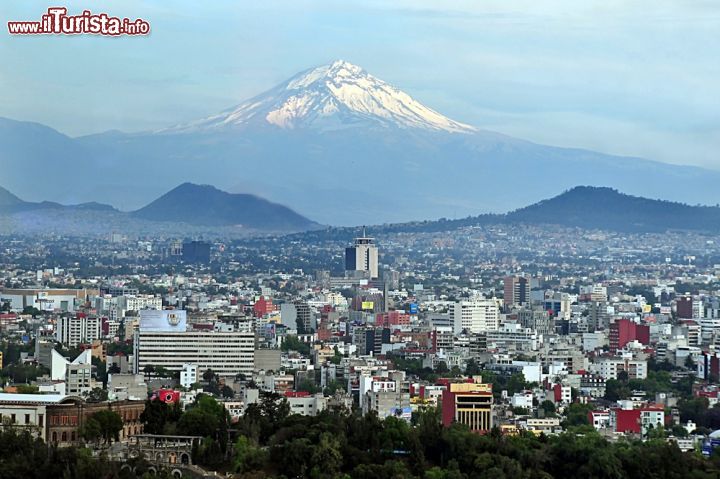 Immagine L'inconfondibile sagoma del vulcano Popocatépetl domina da lontano la vallata su cui si sviluppa Città del Messico. Si tratta del vulcano più attivo del Messico nonché uno dei poù alti del mondo, con i suoi 5500 metri s.l.m. - foto © ChameleonsEye / Shutterstock.com