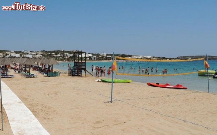 Immagine Spiaggia di Santa Maria a Paros, Grecia. Situato vicino a Naoussa, nella baia di Plastira, questo tratto di litorale è diviso in due spiaggette di sabbia morbida e dorata da cui si gode un panorama incantevole sull'isola di Naxos. Mare trasparente e cristallino con un fondale che digrada dolcemente dalla riva sino al largo caratterizza questo angolo delle Cicladi. La spiaggia è facilmente raggiungibile via terra con i mezzi pubblici e moto ma anche via mare con taxi d'acqua.