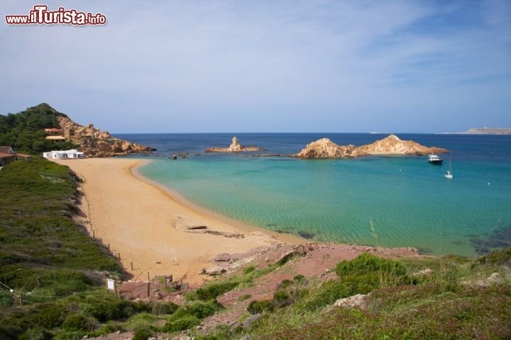 Immagine Cala Pregonda è una bella spiaggia nella parte settentrionale di Minorca, una delle Isole Baleari. E' raggiungibile a piedi in una ventina di minuti dalla spiaggia di Binimella oppure via mare, ha il fondo di sabbia rossa e un'acqua turchese che tende al verde - © Quintanilla / Shutterstock.com