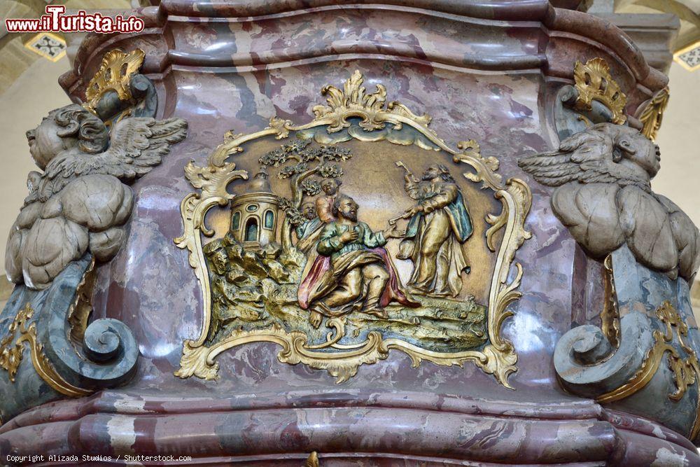 Immagine Dettaglio di una colonna di marmo rosso nella cattedrale di San Pietro a Osnabruck, Germania. La scena religiosa rappresentata è in rilievo e ricoperta da una doratura - © Alizada Studios / Shutterstock.com