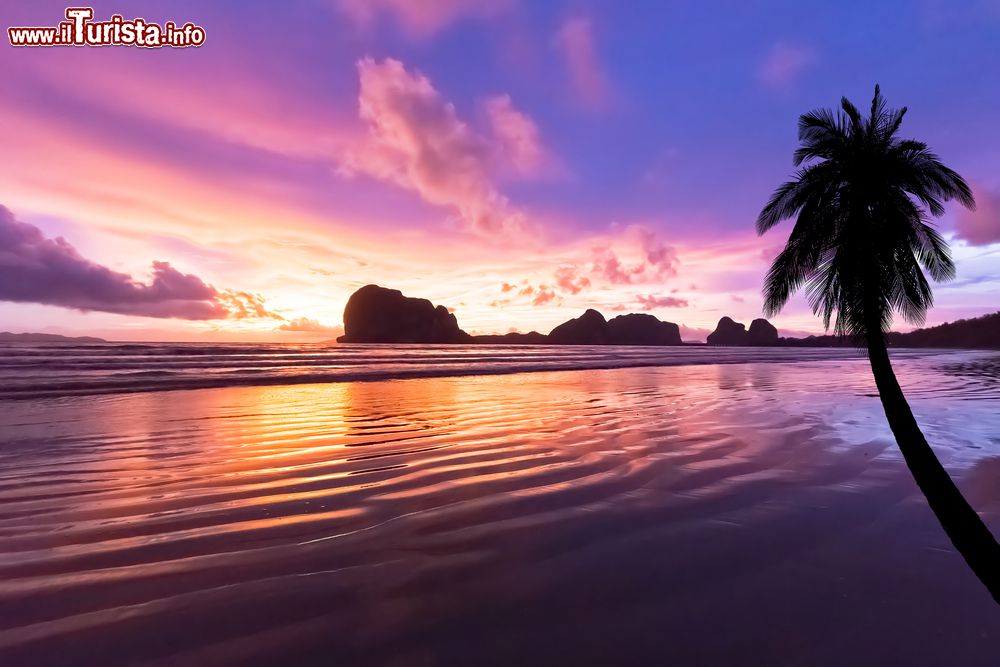 Immagine La spiaggia di Pak Meng, provincia di Trang, Thailandia. Sabbia rosa con tramonto sulll'isola nello sfondo.