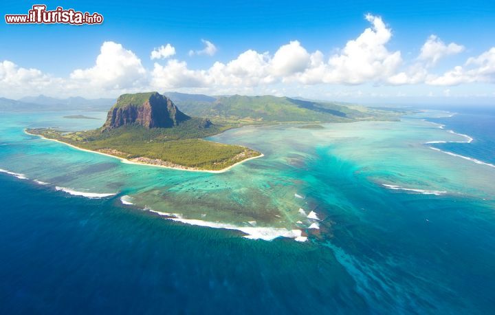 Immagine Le Morne Brabant e la barriera corallina, isola di Mauritius - Formato da un grande blocco di roccia basaltica che si innalza per 550 metri sul livello del mare, Le Morne Brabant è una penisola situata all'estremità sud occidentale di Mauritius di cui è anche una delle principali attrazioni turistiche. Qui vi si trovano infatti alcune piante rarissime come l'hibiscus fragilis e la trochetia boutoniana. Dal 2008 è patrimonio mondiale Unesco © Sapsiwai / Shutterstock.com