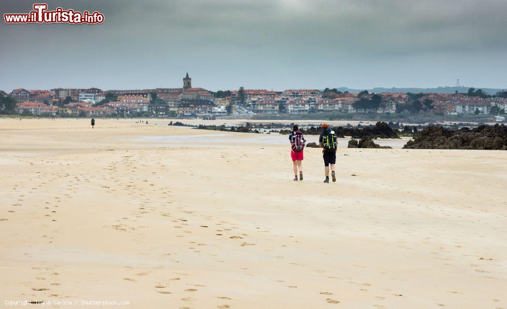 Immagine Pellegrini sul Cammino di Santiago nella spiaggia di Playade el Busco, Noja, Spagna - © Iryna Savina / Shutterstock.com